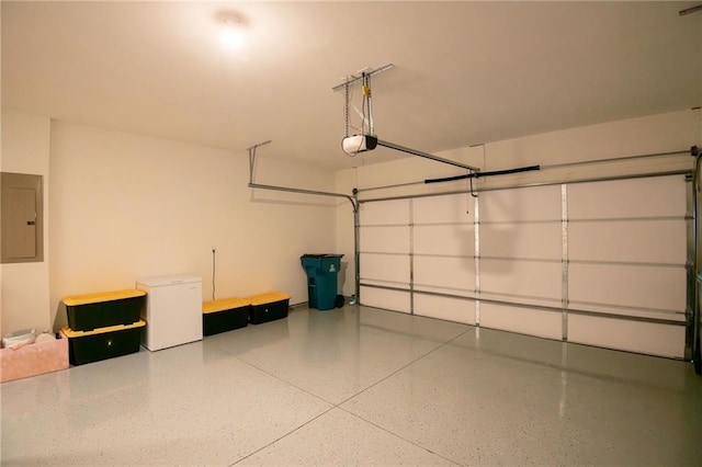 garage featuring refrigerator, electric panel, and a garage door opener