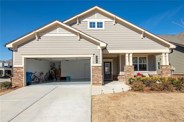 craftsman-style house with stone siding, driveway, and an attached garage