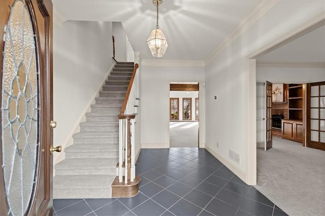 entryway with french doors, crown molding, and dark colored carpet