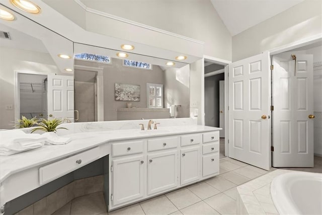 bathroom with vaulted ceiling, tile patterned flooring, independent shower and bath, and vanity