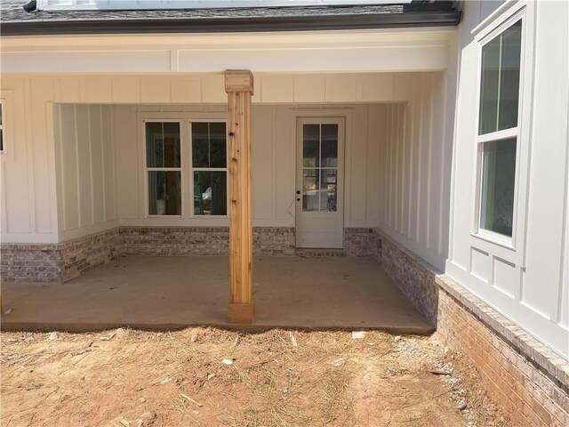 back of property featuring a shingled roof, central AC, and a patio area