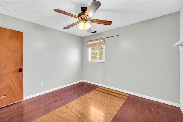 empty room with hardwood / wood-style floors and ceiling fan