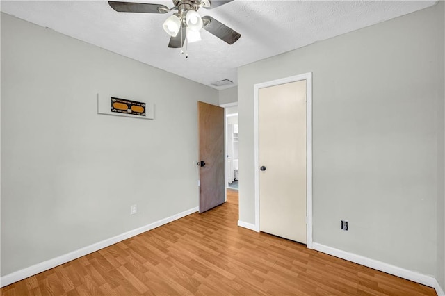 unfurnished bedroom with a textured ceiling, light hardwood / wood-style flooring, and ceiling fan