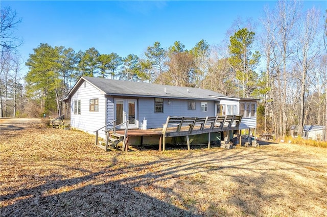 rear view of house featuring french doors, a wooden deck, and a sunroom