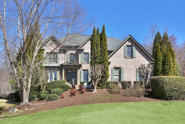 view of front of property with a front yard and brick siding