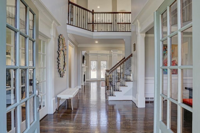 foyer entrance featuring visible vents, stairway, ornamental molding, french doors, and wood finished floors