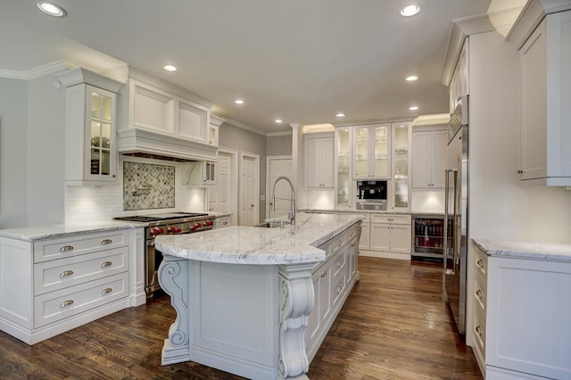 kitchen with crown molding, dark wood-type flooring, high quality appliances, white cabinets, and a sink