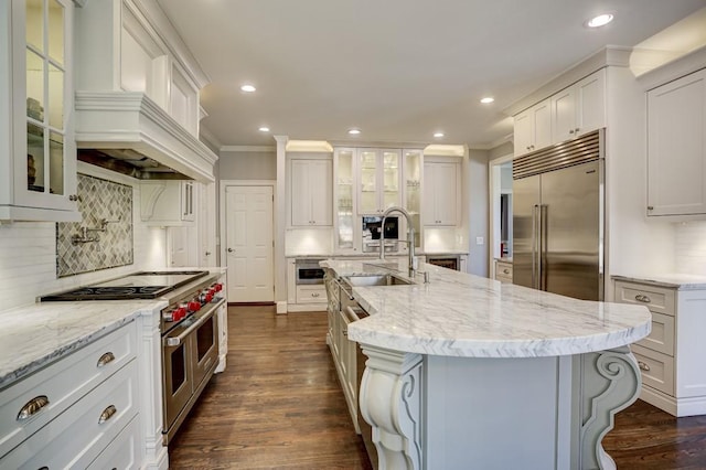 kitchen with ornamental molding, a sink, recessed lighting, high end appliances, and dark wood-style flooring