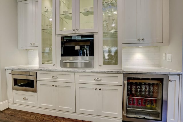 bar featuring wine cooler, decorative backsplash, and dark wood-style flooring