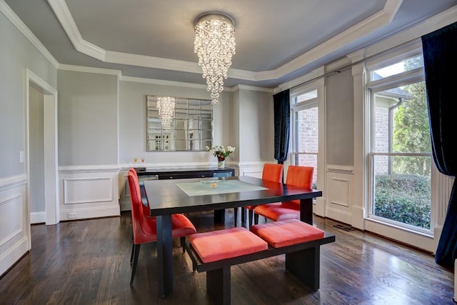 dining area featuring a raised ceiling, a notable chandelier, and dark wood-style flooring