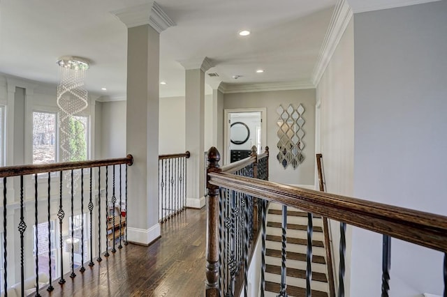 corridor featuring baseboards, an upstairs landing, wood finished floors, and crown molding