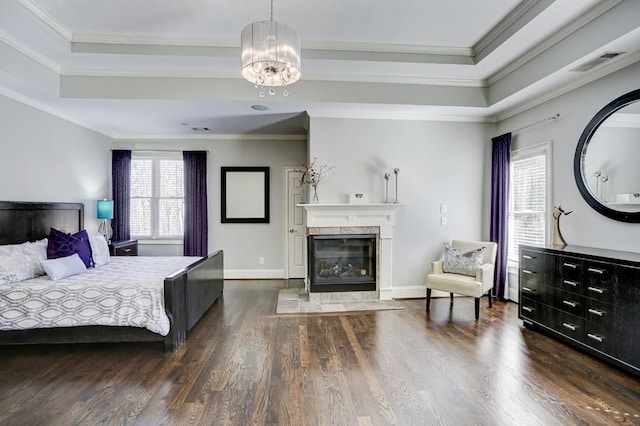 bedroom featuring dark wood-style floors, visible vents, and a raised ceiling