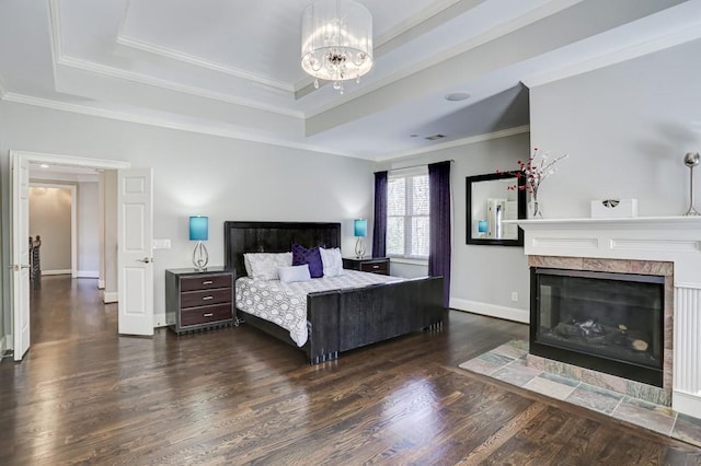 bedroom featuring crown molding, baseboards, a tray ceiling, an inviting chandelier, and wood finished floors