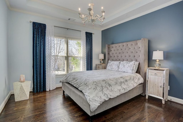 bedroom featuring baseboards, a tray ceiling, ornamental molding, wood finished floors, and a notable chandelier