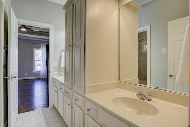 full bath featuring tile patterned floors, walk in shower, vanity, and baseboards