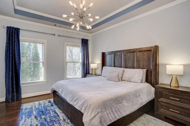 bedroom with a tray ceiling, visible vents, wood finished floors, and an inviting chandelier