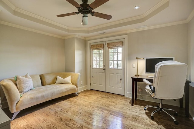 office with ceiling fan, a raised ceiling, wood finished floors, and ornamental molding