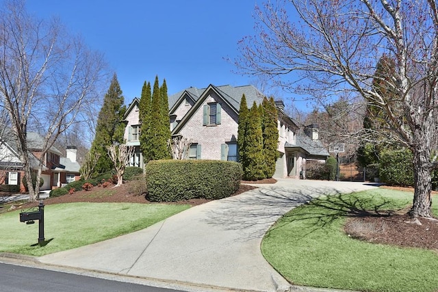 tudor house featuring a front yard and driveway