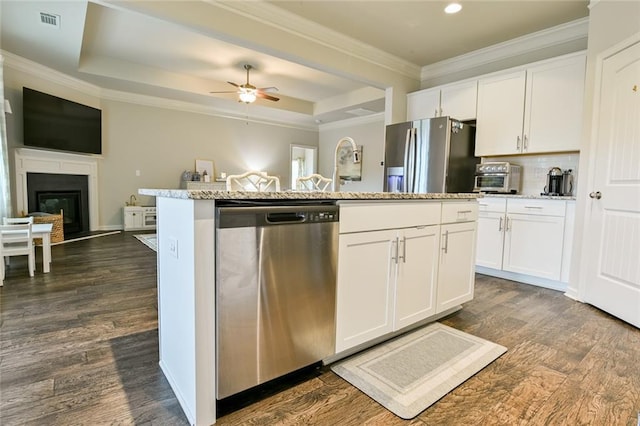 kitchen with appliances with stainless steel finishes, open floor plan, a ceiling fan, white cabinets, and a kitchen island with sink