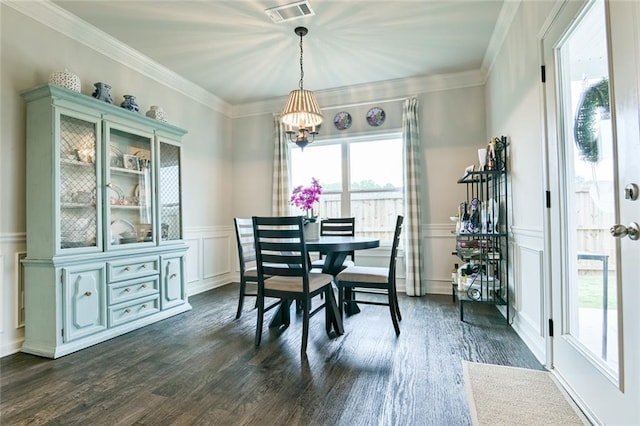 dining room with a decorative wall, a chandelier, dark wood finished floors, a wainscoted wall, and ornamental molding