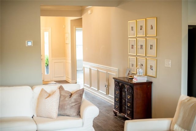 living area featuring wood finished floors and a wainscoted wall