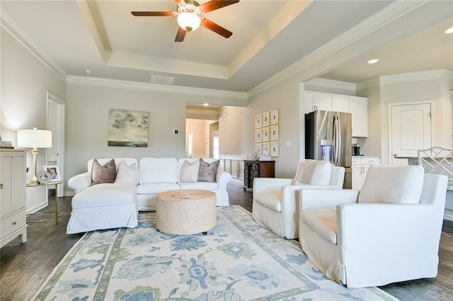 living area featuring a ceiling fan, wood finished floors, a raised ceiling, ornamental molding, and recessed lighting