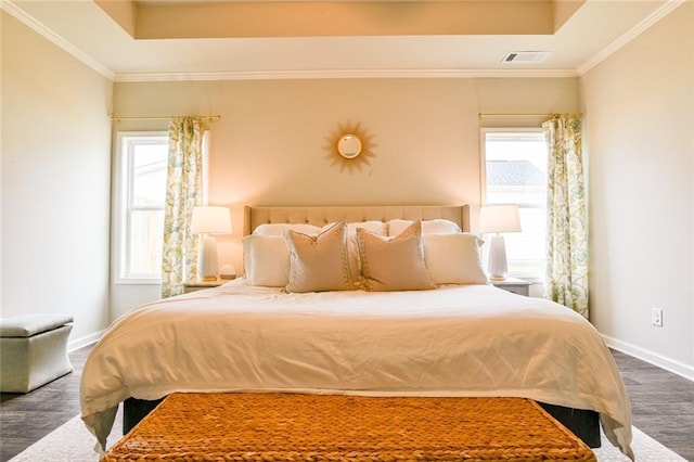 bedroom featuring wood finished floors, baseboards, multiple windows, and ornamental molding