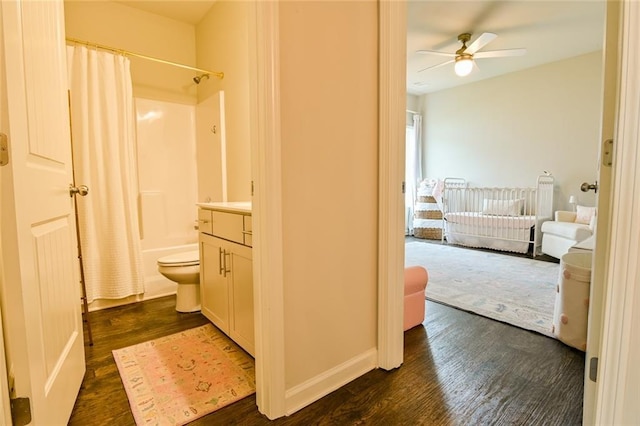 full bath with wood finished floors, a ceiling fan, shower / bath combo with shower curtain, vanity, and toilet