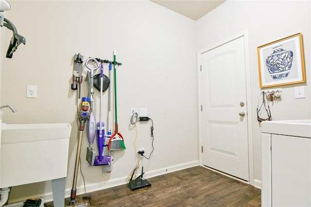 laundry room featuring dark wood-style flooring, washer / clothes dryer, a sink, and baseboards