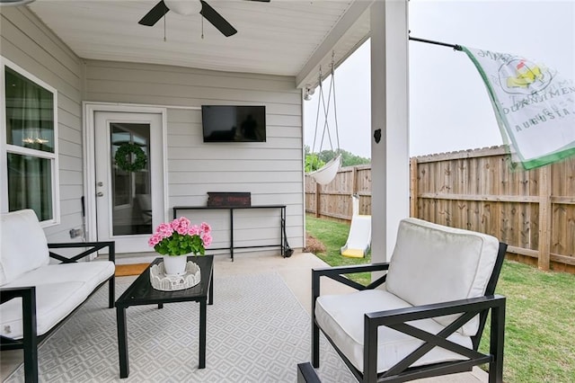 view of patio / terrace with fence, an outdoor hangout area, and a ceiling fan