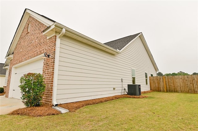 view of side of home with brick siding, an attached garage, concrete driveway, and central AC unit