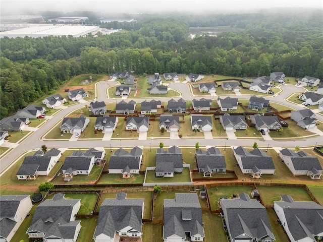 aerial overview of property's location featuring nearby suburban area and a forest