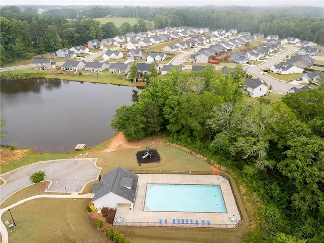 aerial view of property's location with nearby suburban area, a pool, and a large body of water
