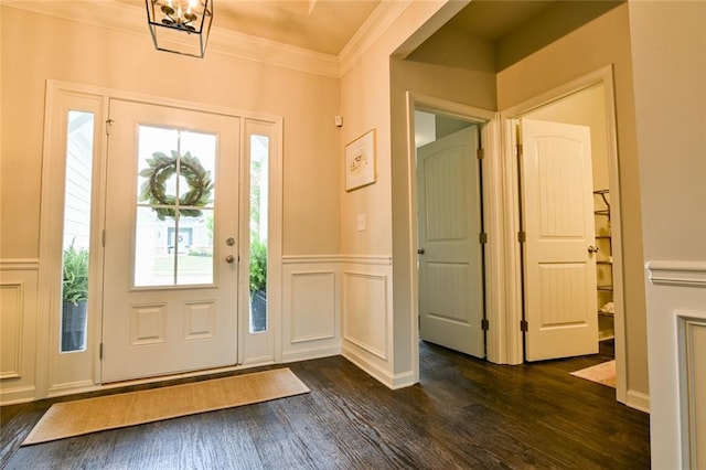 foyer entrance featuring dark wood-style flooring, crown molding, and a decorative wall