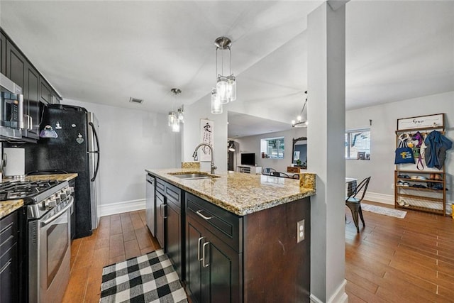 3048 Briarcliff Rd NE Unit 9, Atlanta, GA 30329 - kitchen featuring appliances with stainless steel finishes, dark wood-type flooring, light stone counters, and hanging light fixtures