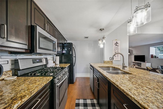 3048 Briarcliff Rd NE Unit 9, Atlanta, GA 30329 - kitchen with stainless steel appliances, light stone countertops, dark wood-style floors, dark brown cabinetry, and decorative light fixtures