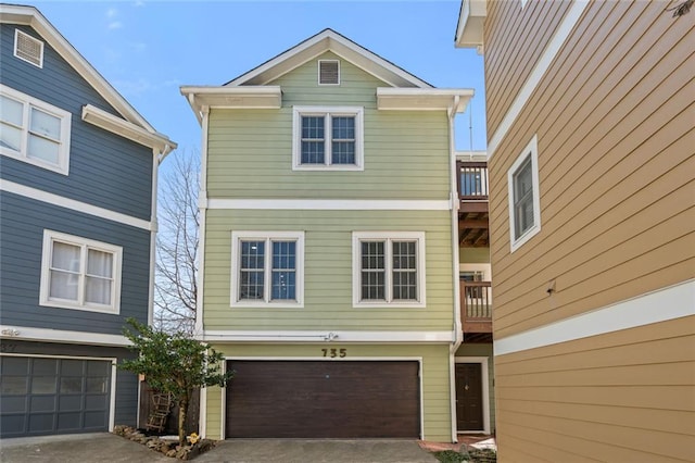 view of front of property featuring a balcony, an attached garage, and driveway
