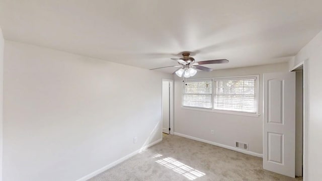 unfurnished room featuring light carpet, baseboards, visible vents, and ceiling fan