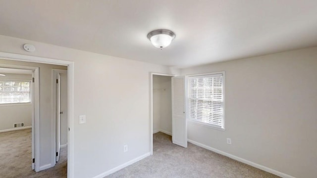 unfurnished bedroom featuring a closet, carpet, visible vents, and baseboards