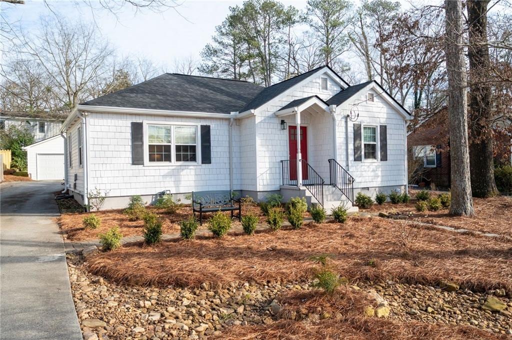 view of front of property featuring a garage and an outdoor structure