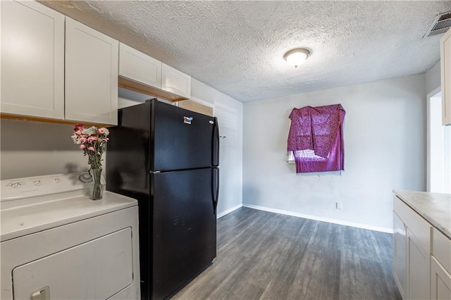 821 Charles Cir, Griffin, GA 30224 - kitchen with washer / dryer, freestanding refrigerator, dark wood finished floors, white cabinetry, and light countertops