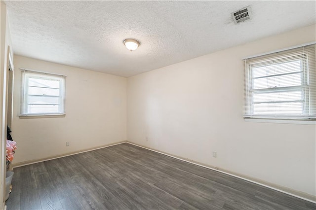 821 Charles Cir, Griffin, GA 30224 - unfurnished room featuring dark wood-style floors, a textured ceiling, plenty of natural light, and baseboards