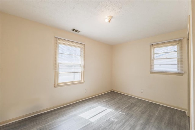 821 Charles Cir, Griffin, GA 30224 - spare room featuring wood finished floors, healthy amount of natural light, baseboards, and a textured ceiling