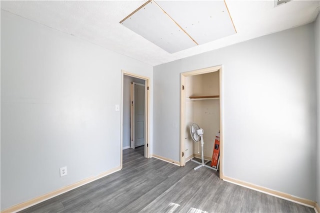 821 Charles Cir, Griffin, GA 30224 - unfurnished bedroom with wood finished floors, baseboards, attic access, and a closet