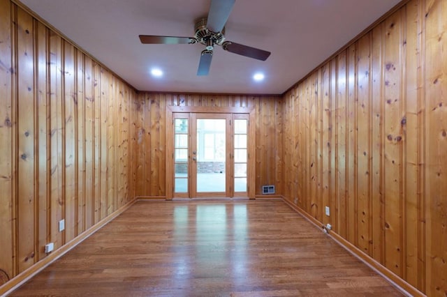 empty room with light wood finished floors, baseboards, visible vents, and a ceiling fan