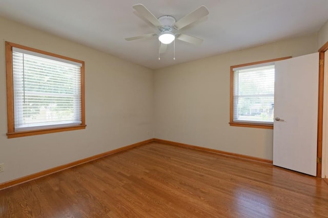 unfurnished room featuring a ceiling fan, light wood-type flooring, and baseboards