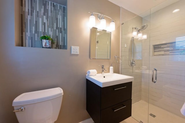 bathroom featuring a stall shower, vanity, and toilet