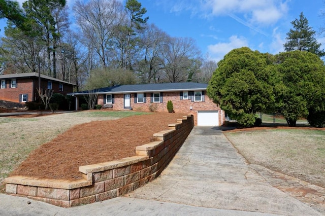 single story home featuring brick siding, driveway, and an attached garage