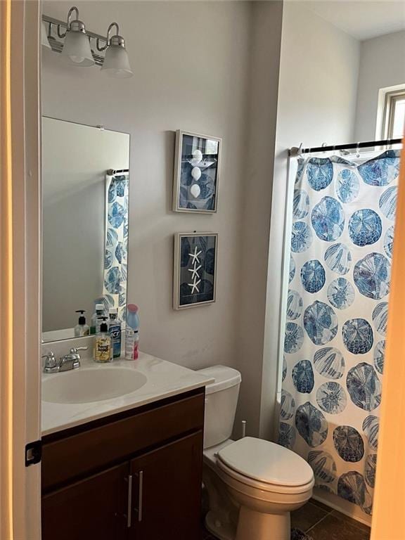 bathroom with toilet, vanity, and a shower with shower curtain