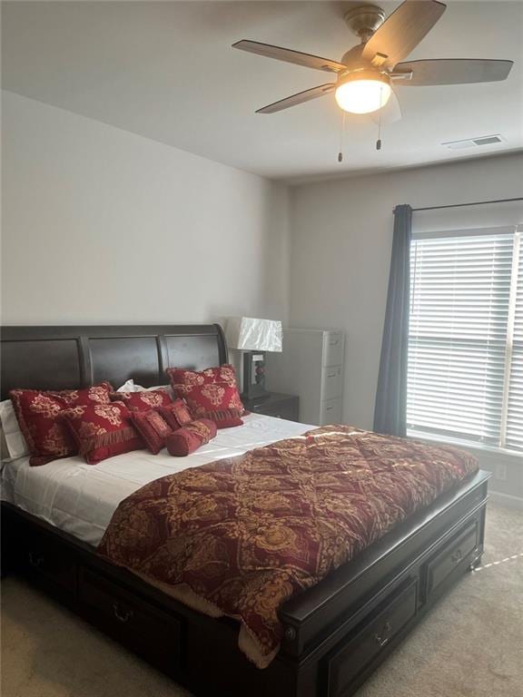 carpeted bedroom with ceiling fan and visible vents